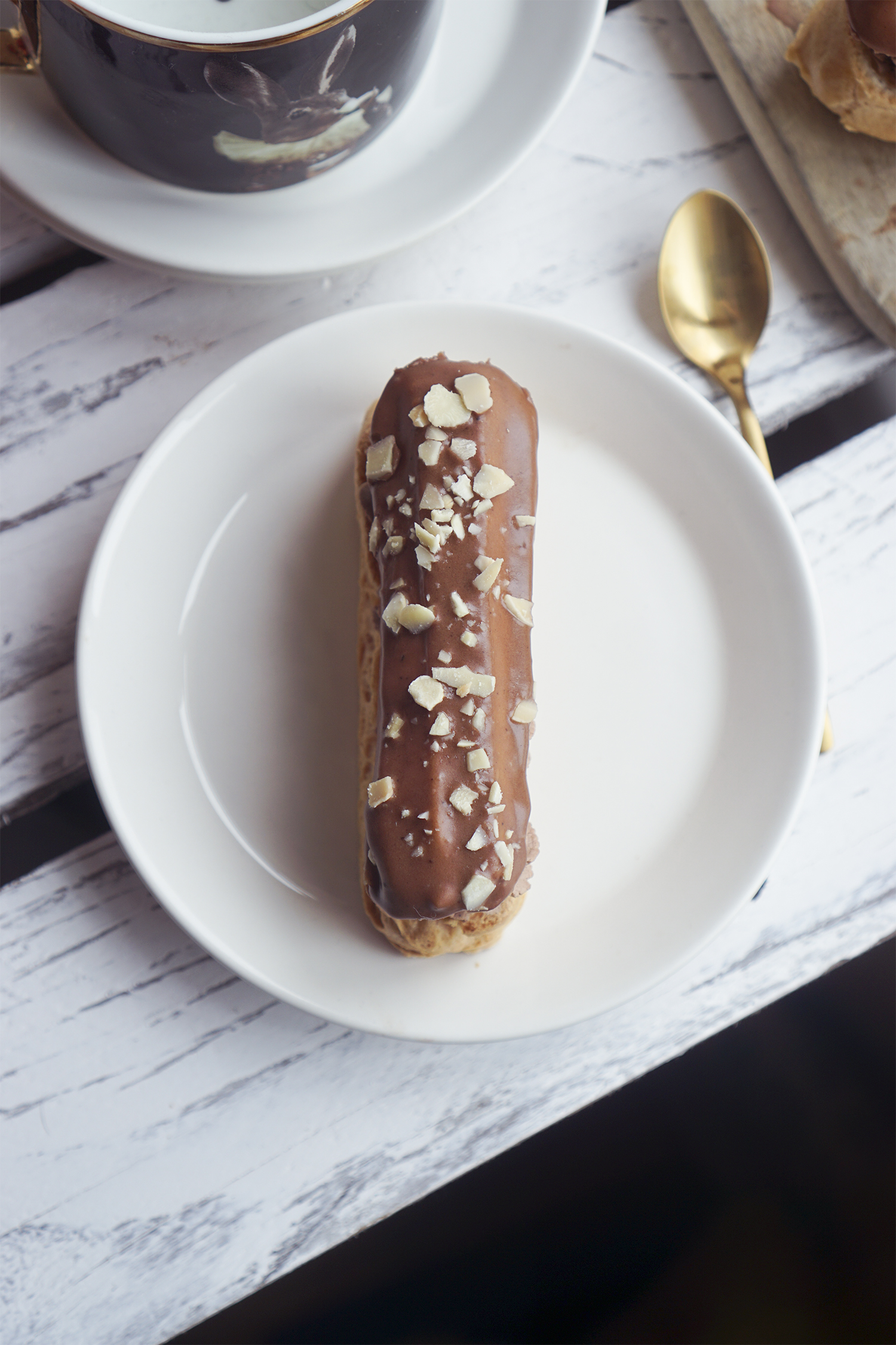 Gluten free eclairs topped with chocolate icing and crushed flaked almonds